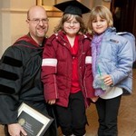 honored faculty member smiles for photo with two children